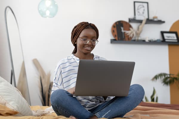 A learner comparing online Yoruba and Igbo courses on a laptop